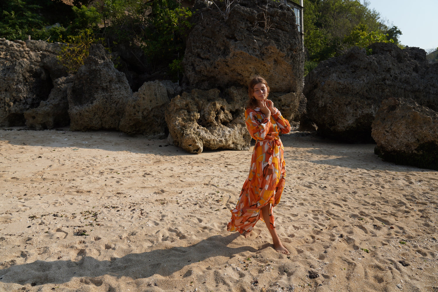 Beautiful model on a beach in Bali, wearing the Nina Maxi Dress in Sunset by Analia the label.